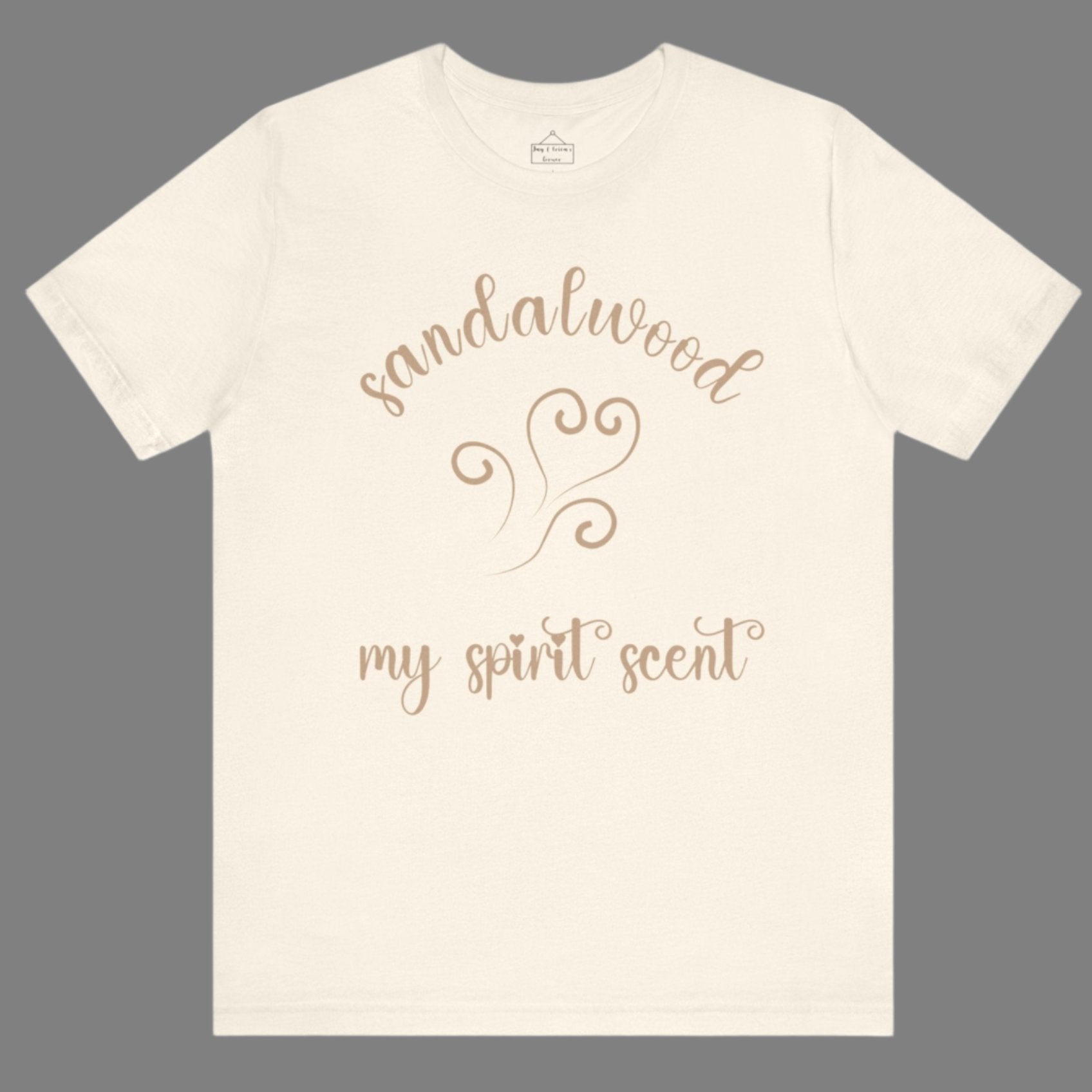 The My Spirit Scent is Sandalwood t-shirt in natural featuring script font and an aroma script heart in a warm, muted beige hue