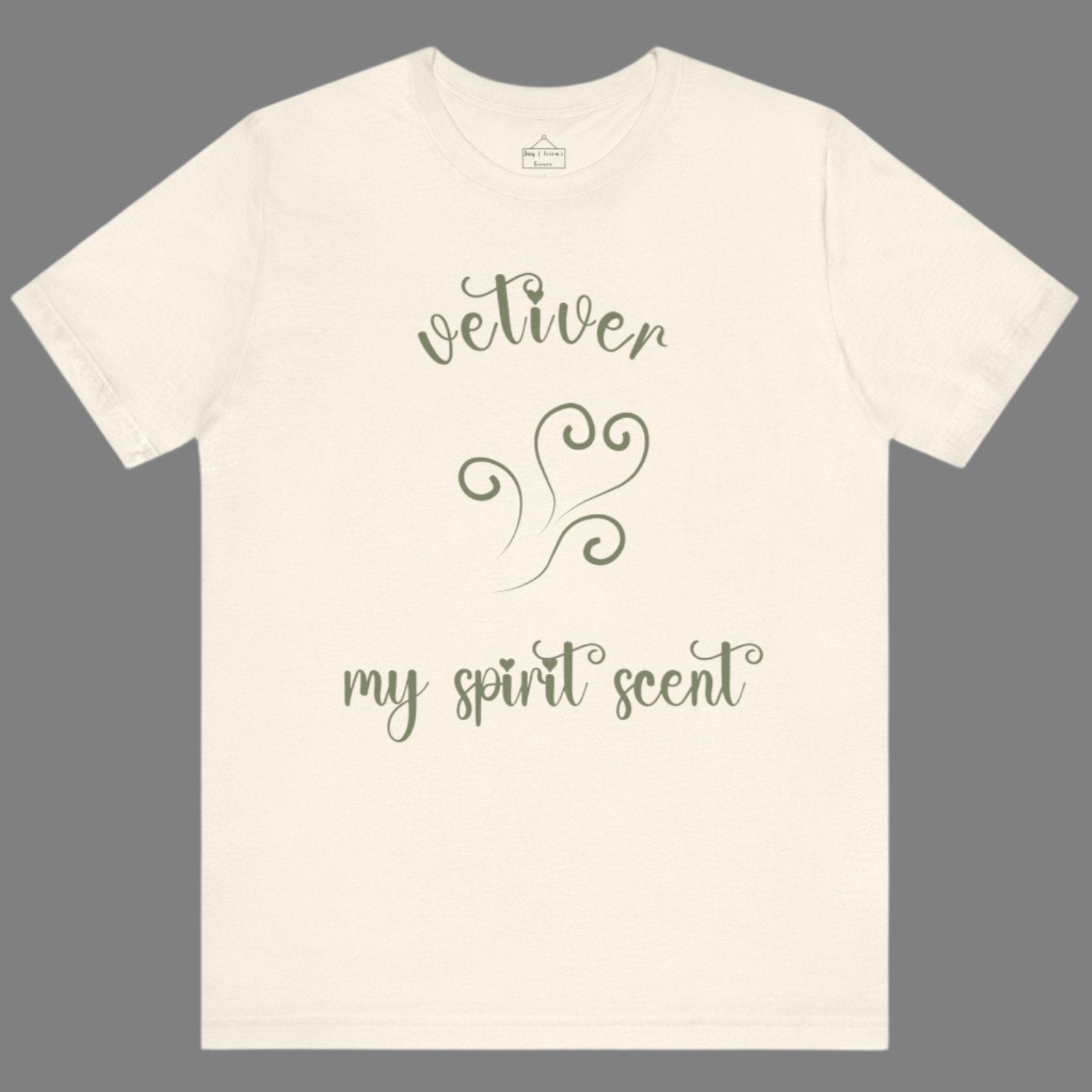 The My Spirit Scent is Vetiver t-shirt in natural featuring script font and an aroma script heart in a grey-green hue