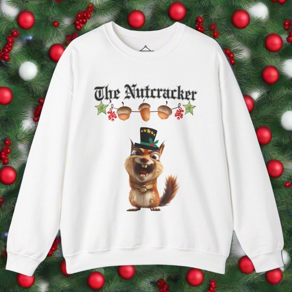 The Nutcracker christmas sweatshirt in white featuring a strand of acorns hanging above a squirrel making a goofy face wearing a black top hat with a green ribbon and gold stars