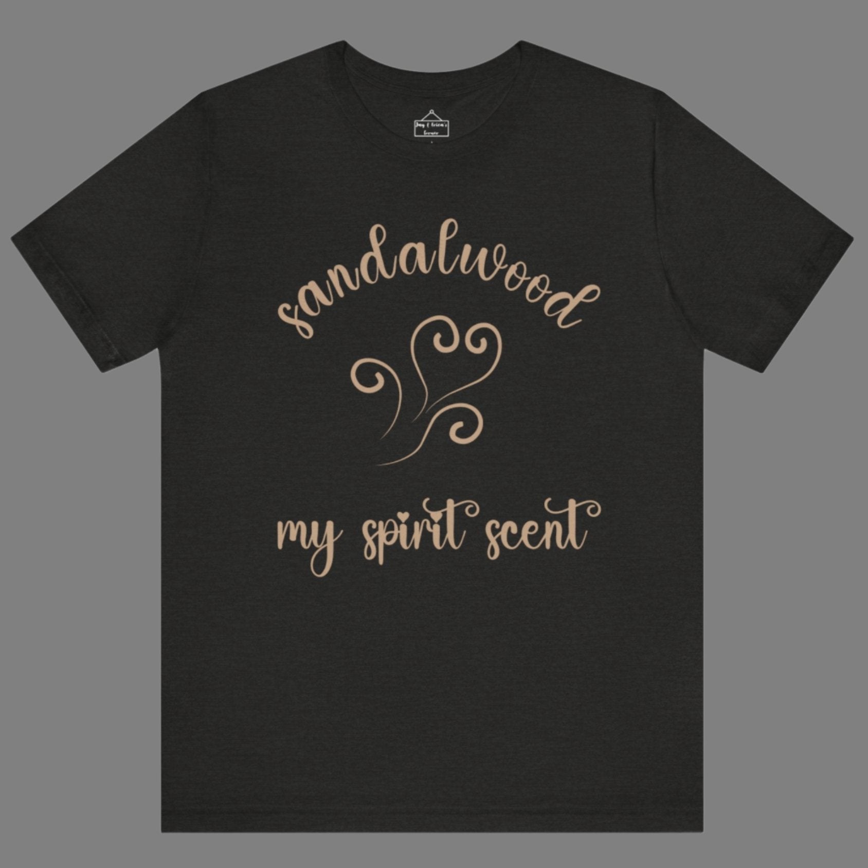 The My Spirit Scent is Sandalwood t-shirt in black heather featuring script font and an aroma script heart in a warm, muted beige hue