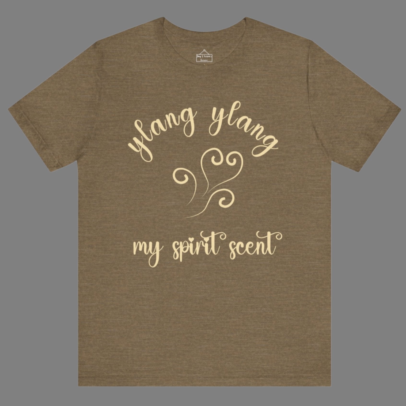 The My Spirit Scent is Ylang Ylang t-shirt in heather olive featuring script font and an aroma script heart in a soft, pastel yellow hue