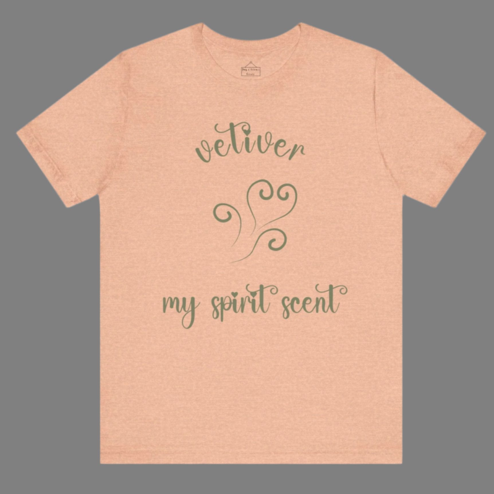 The My Spirit Scent is Vetiver t-shirt in heather peach featuring script font and an aroma script heart in a grey-green hue