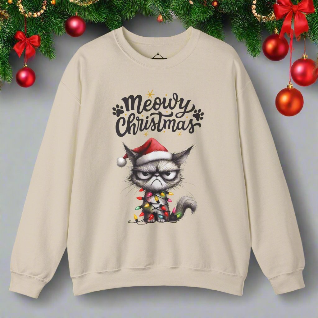 Grumpy Meowy Christmas Sweatshirt in sand with the words Meowy Christmas and a grumpy cat with a red hat and wrapped up in lights