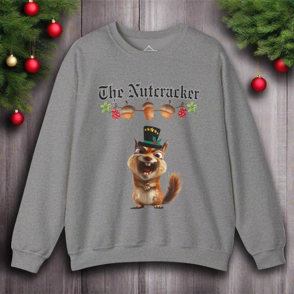 The Nutcracker christmas sweatshirt in graphite heather featuring a strand of acorns hanging above a squirrel making a goofy face wearing a black top hat with a green ribbon and gold stars