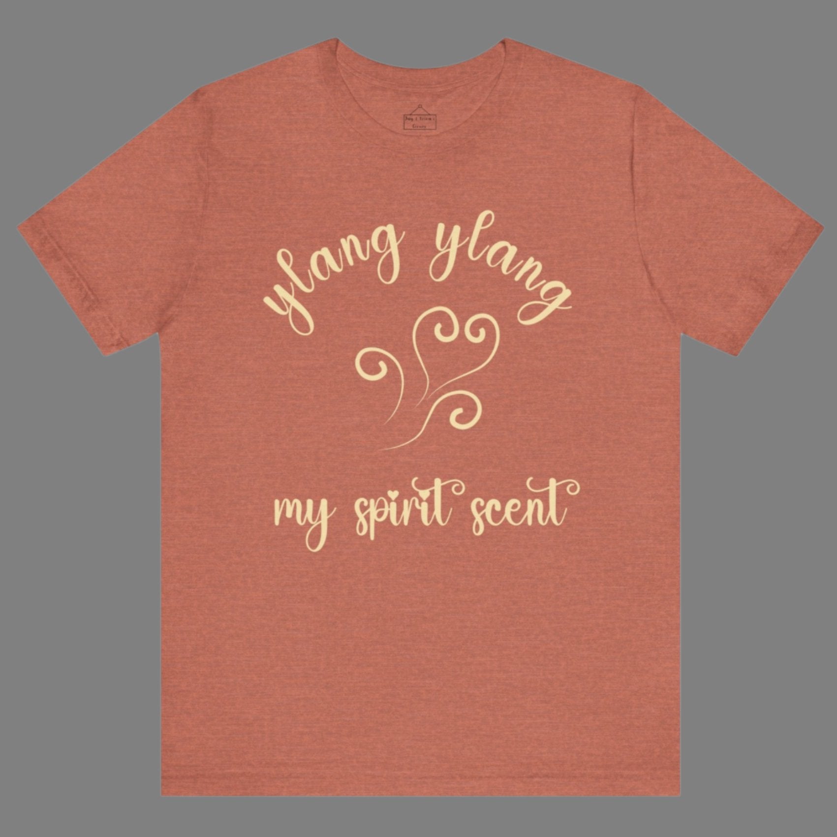 The My Spirit Scent is Ylang Ylang t-shirt in heather clay featuring script font and an aroma script heart in a soft, pastel yellow hue