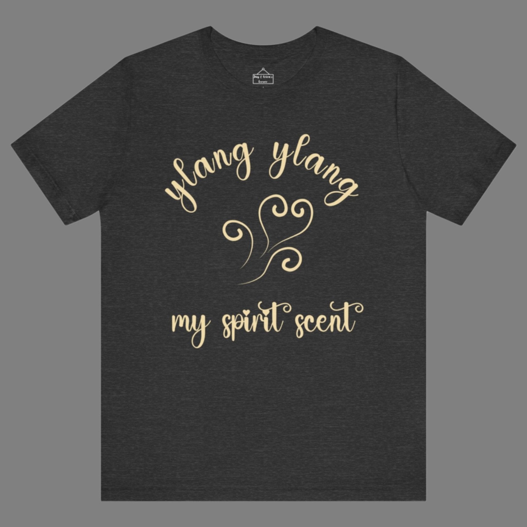 The My Spirit Scent is Ylang Ylang t-shirt in dark grey heather featuring script font and an aroma script heart in a soft, pastel yellow hue