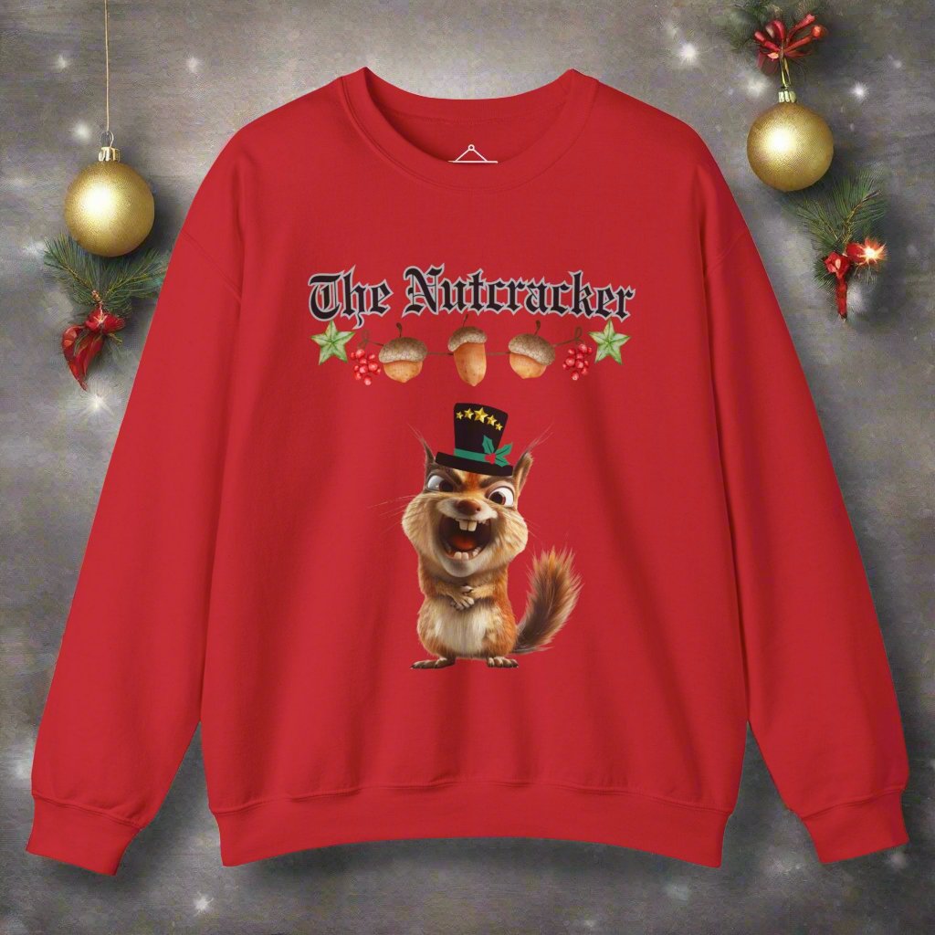 The Nutcracker christmas sweatshirt in red featuring a strand of acorns hanging above a squirrel making a goofy face wearing a black top hat with a green ribbon and gold stars