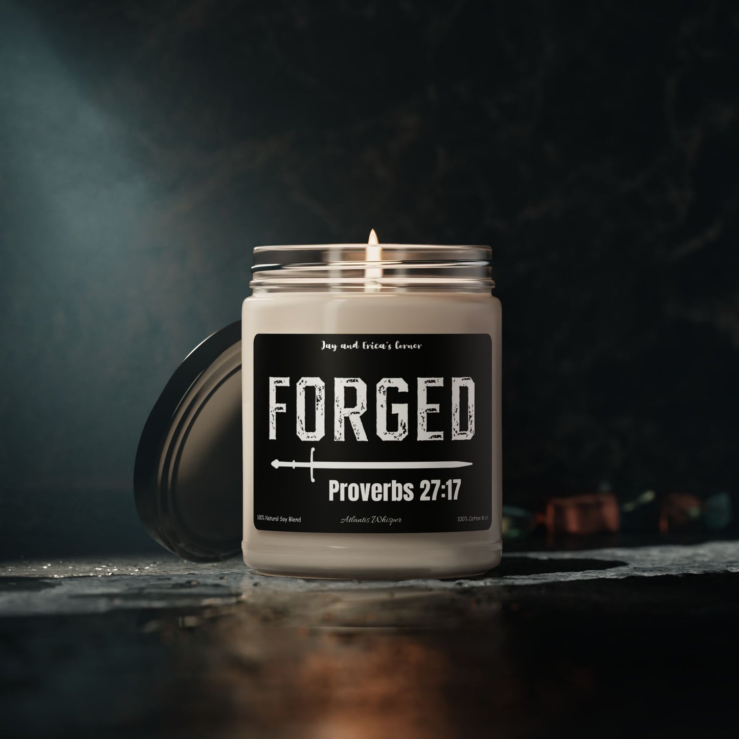 9 oz soy candle in a clear candle jar and a black label with the word forged with a sword and Proverbs 27:17 under it.