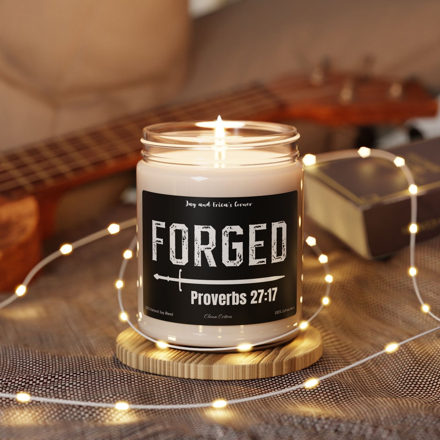 9 oz soy candle in a clear candle jar and a black label with the word forged with a sword and Proverbs 27:17 under it.