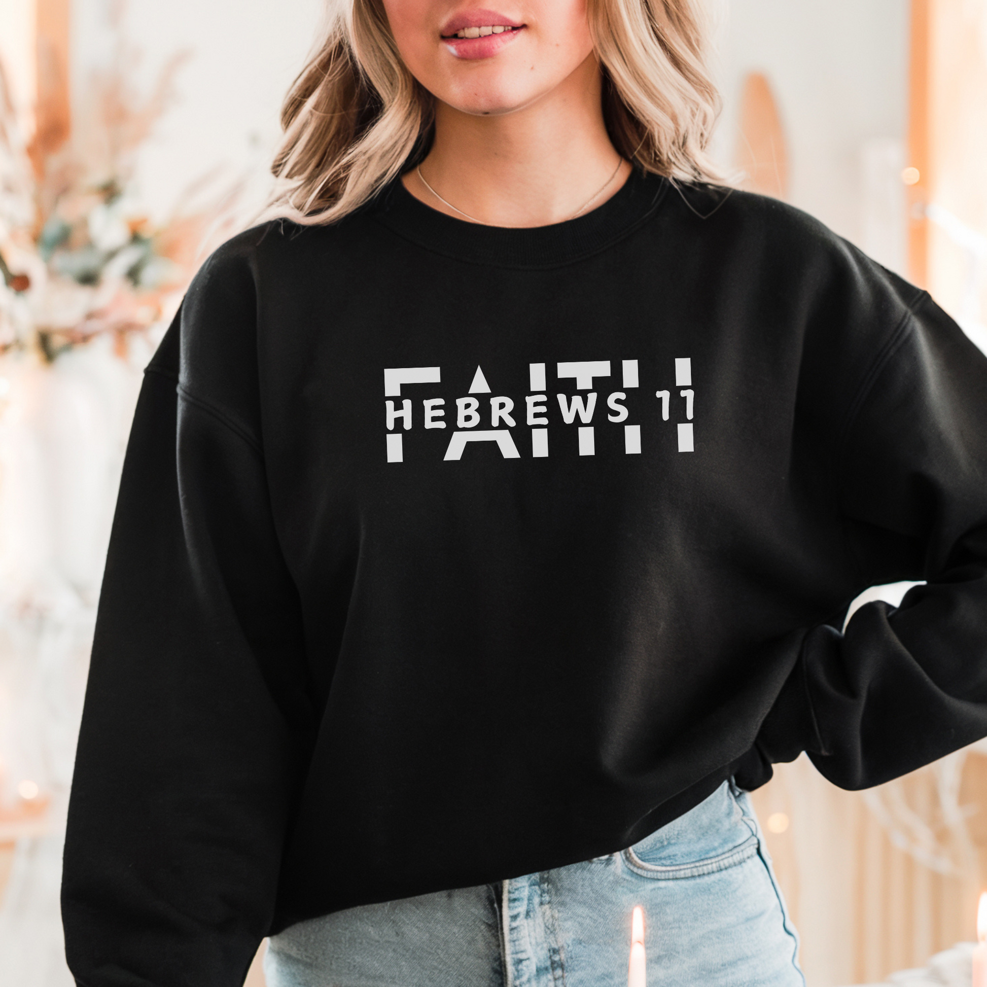 A smiling woman wearing the FAITH Hebrews 11 sweatshirt in black featuring the word faith with Hebrews 11 cut between the letters all in white print