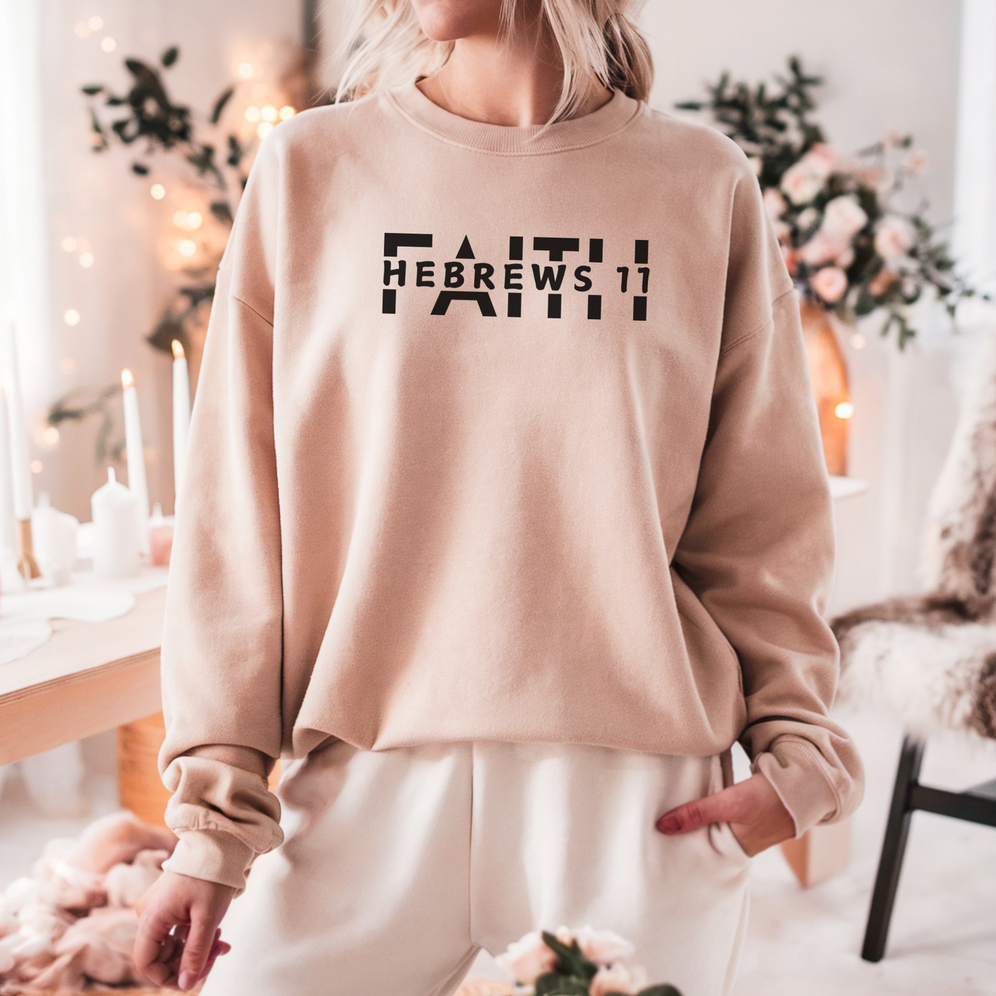 A smiling woman wearing the FAITH Hebrews 11 sweatshirt in sand featuring the word faith with Hebrews 11 cut between the letters all in black print