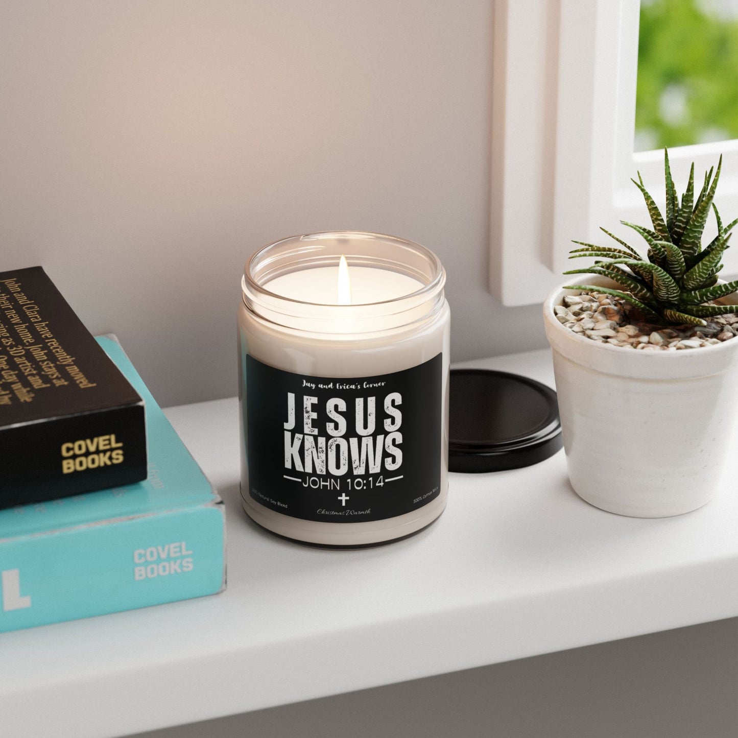 Jesus Knows John 10:14 scented soy candle in a clear glass jar, a black label, and white font